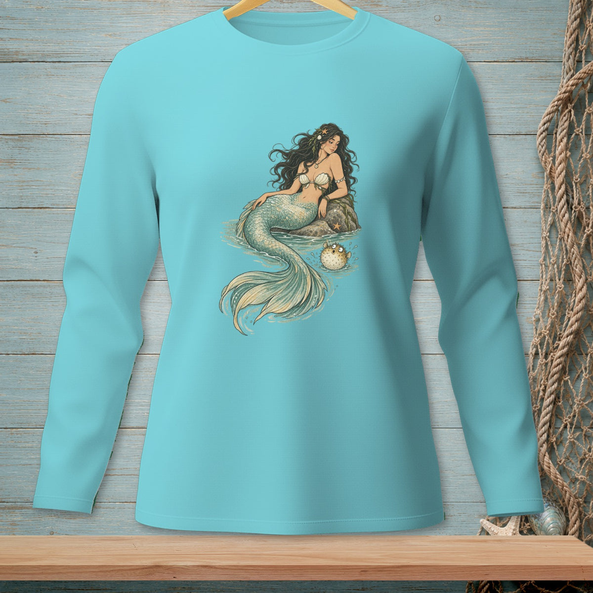 Light blue long-sleeved shirt with a graphic of a mermaid and pufferfish.