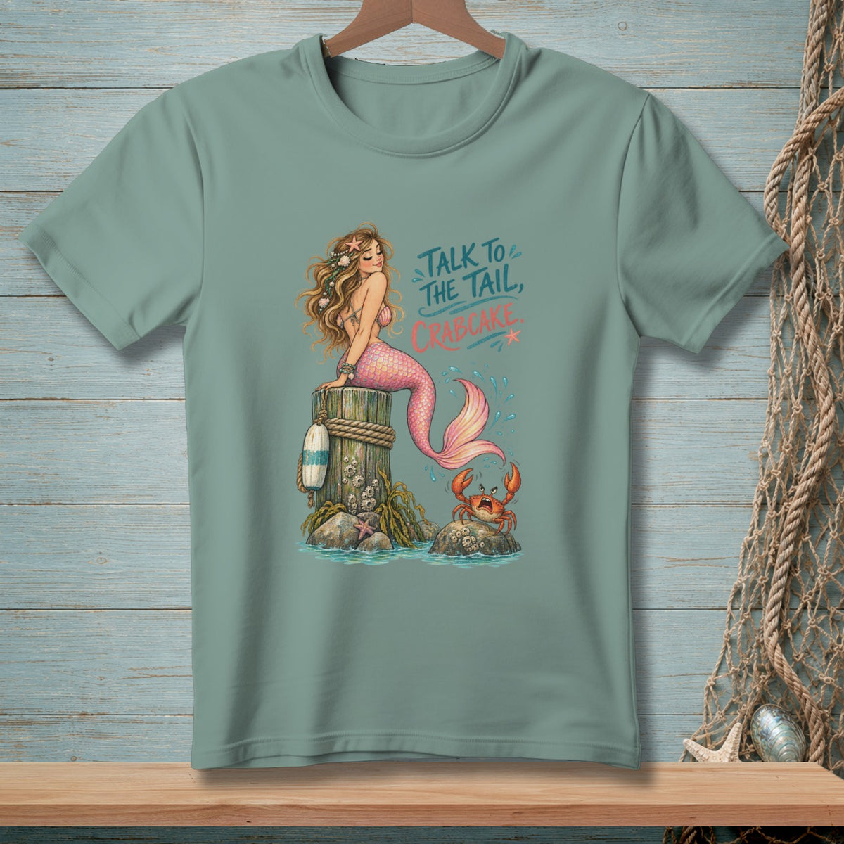 Mermaid sitting on a post with a crab, text says "Talk to the tail, Crabcake."