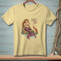 Light yellow t-shirt with a mermaid and lobster graphic and text "Don't Stop Now."
