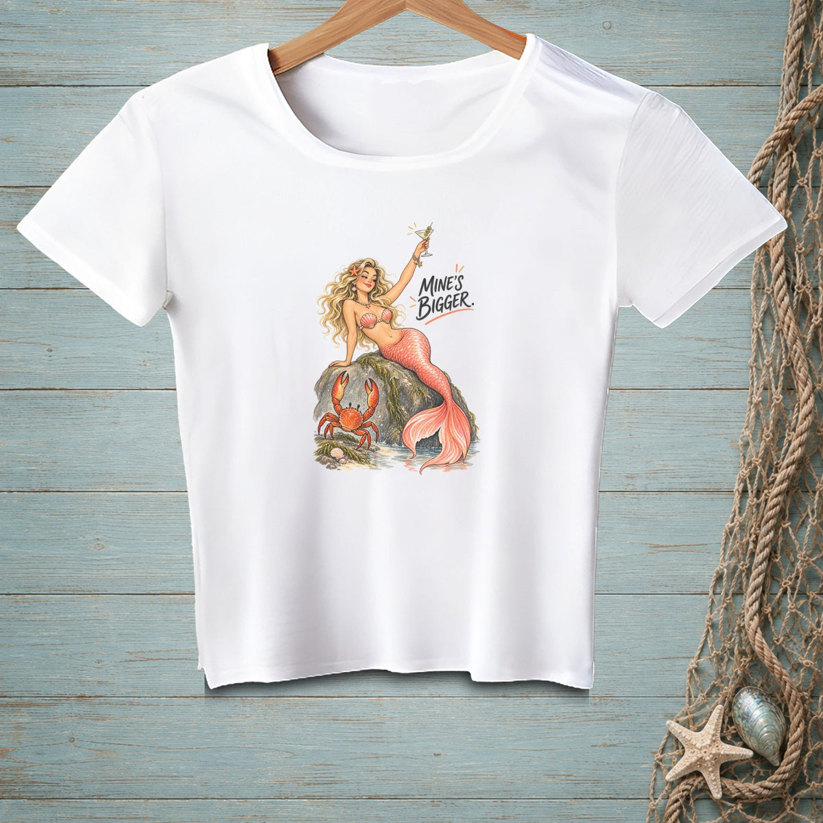 White t-shirt with illustration of a mermaid and crab, text "MINE'S BIGGER."