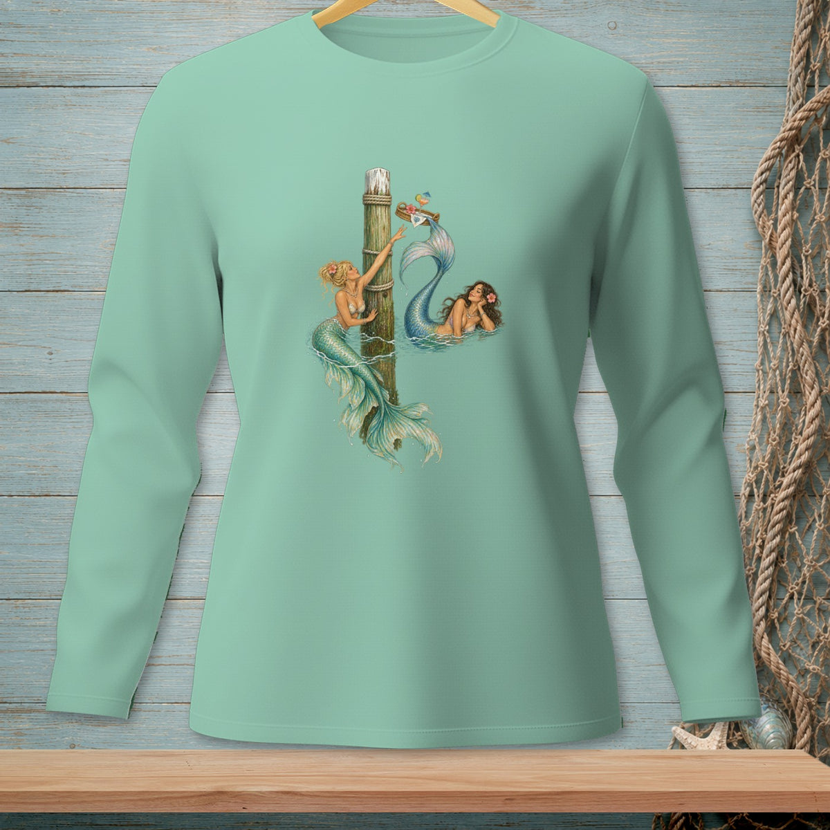 Mint long sleeve shirt with two mermaids and a wooden post design.