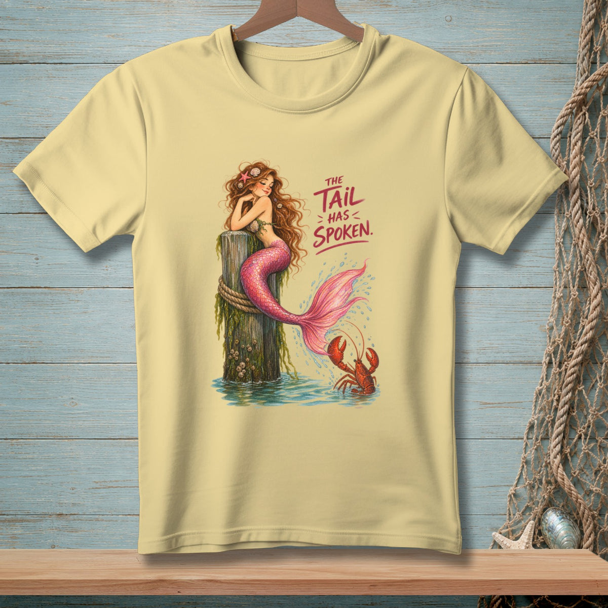 A mermaid sits on a post with a lobster and the text "The Tail Has Spoken."