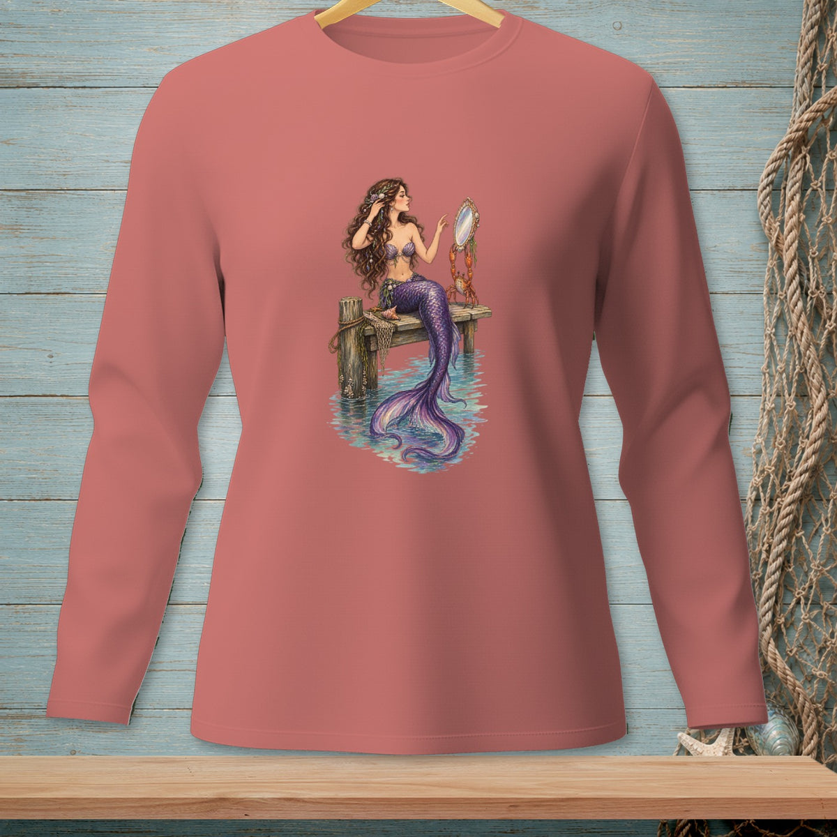 Long-sleeved pink shirt with a mermaid grooming her hair in a mirror.