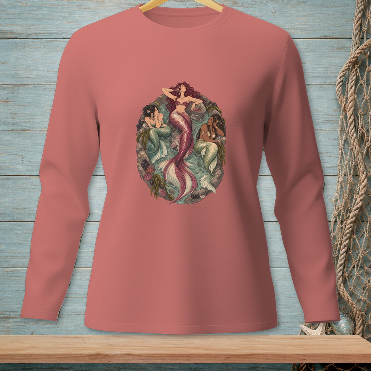 Long sleeve pink t-shirt with three mermaids in a circular ocean design.
