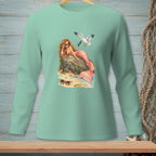 Mermaid with sunglasses and pink tail rests on rock; seagull flies by.
