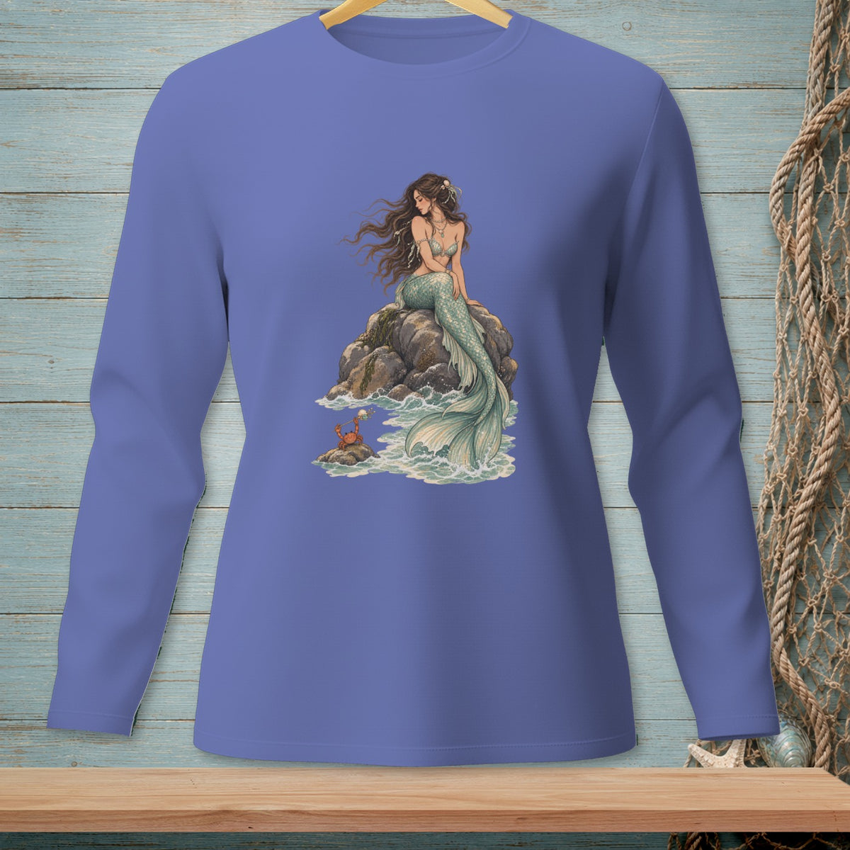 Mermaid sitting on a rock with a crab, on a purple long-sleeve shirt.