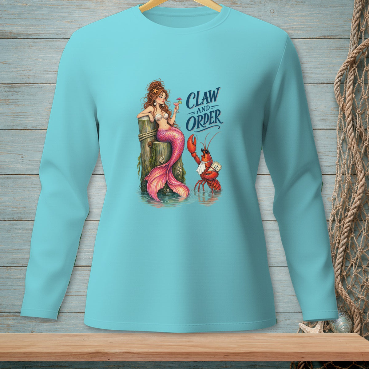 Mermaid and lobster graphic with "Claw and Order" text on a teal long-sleeve shirt.