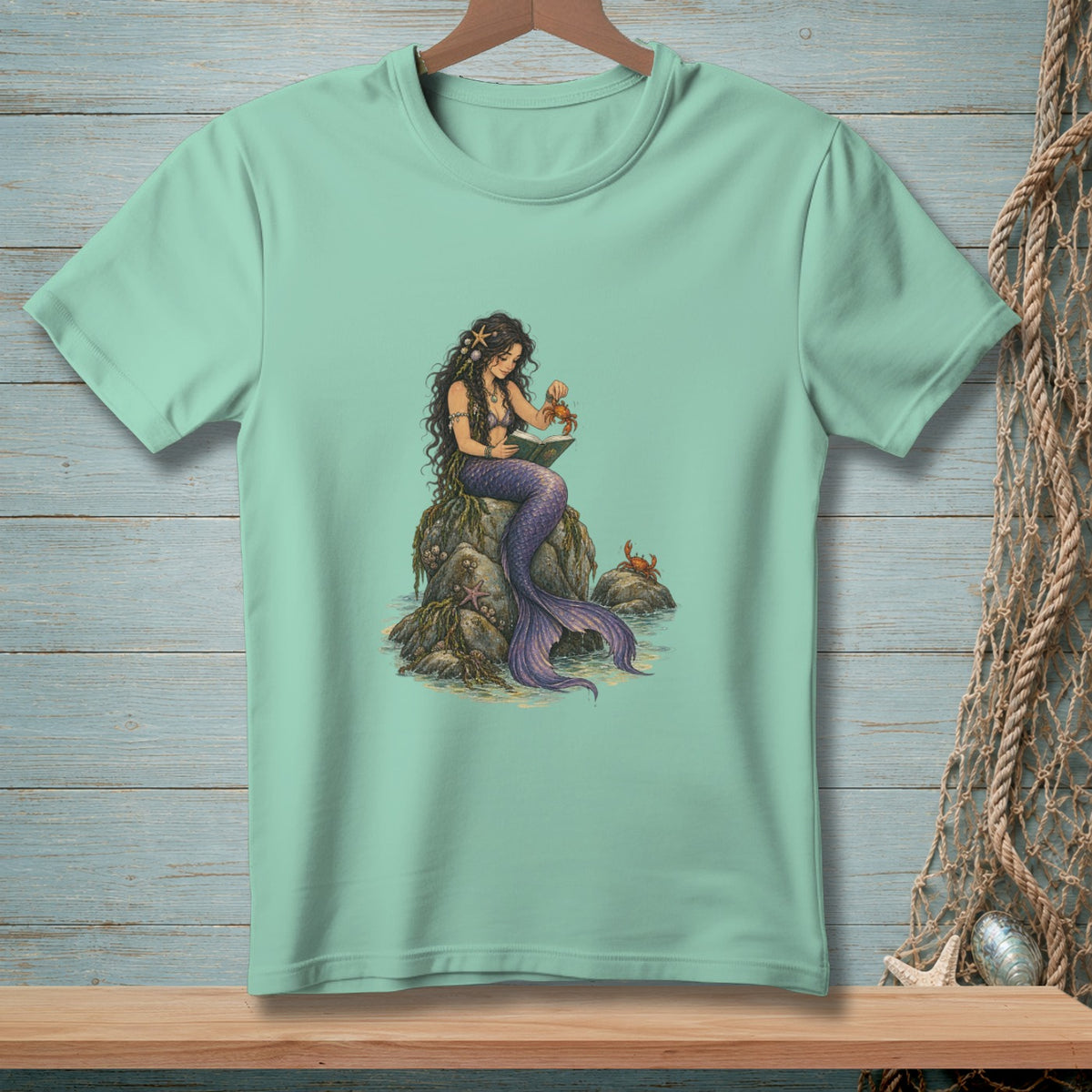 Mermaid with purple tail reading on a rock with crabs and starfish.