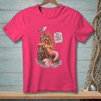 Pink t-shirt featuring a mermaid on a pilings with a seagull and sign saying "Don't judge my current situation."