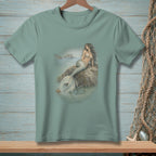 T-shirt with a print of a mermaid sitting on a rock in the ocean.