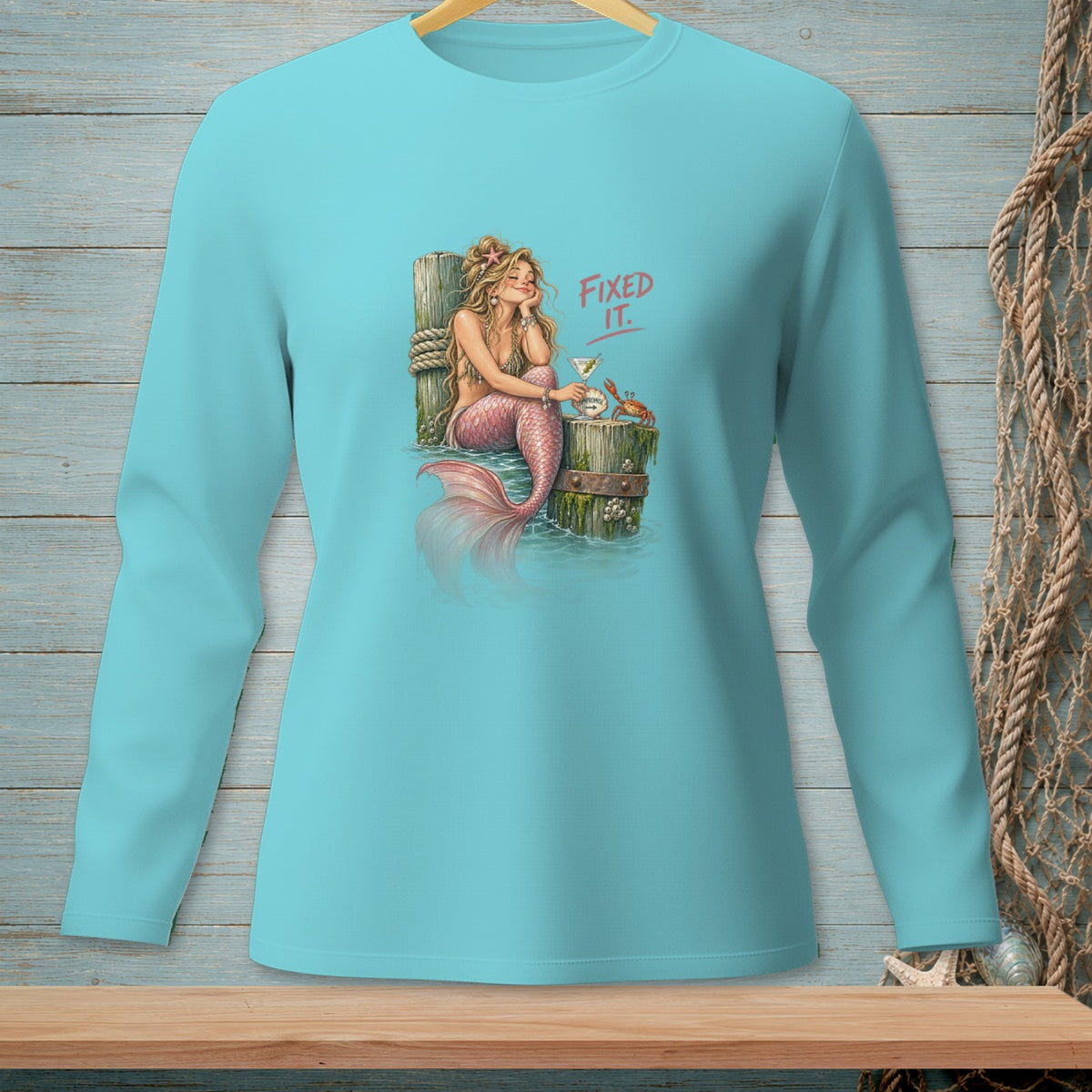 Turquoise long-sleeve shirt with a mermaid, martini, crab, and text "FIXED IT."