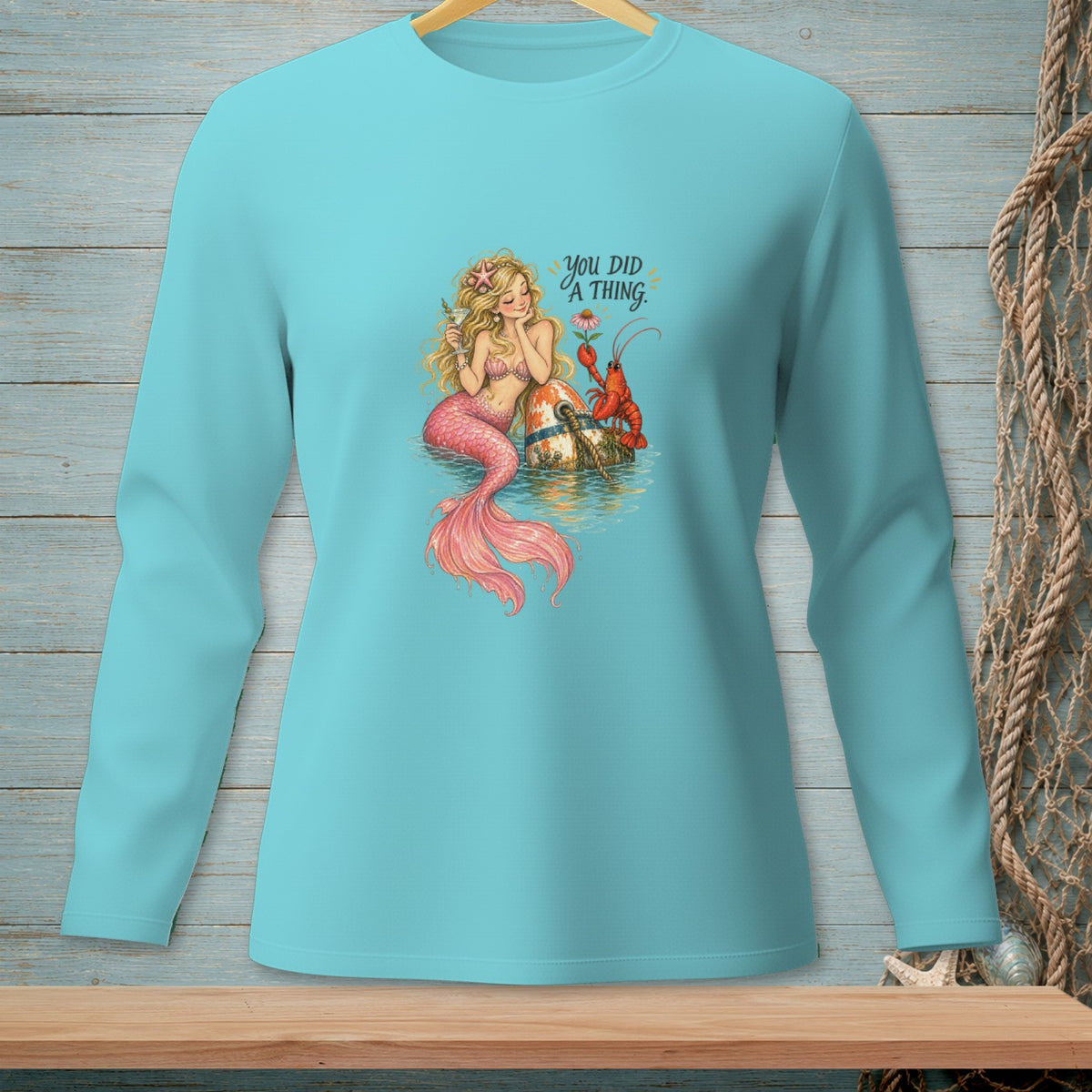 Mermaid and lobster graphic with text "You did a thing" on a teal long-sleeve shirt.