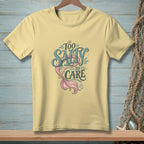 Pale yellow t-shirt with "Too Salty To Care" and a mermaid tail graphic.