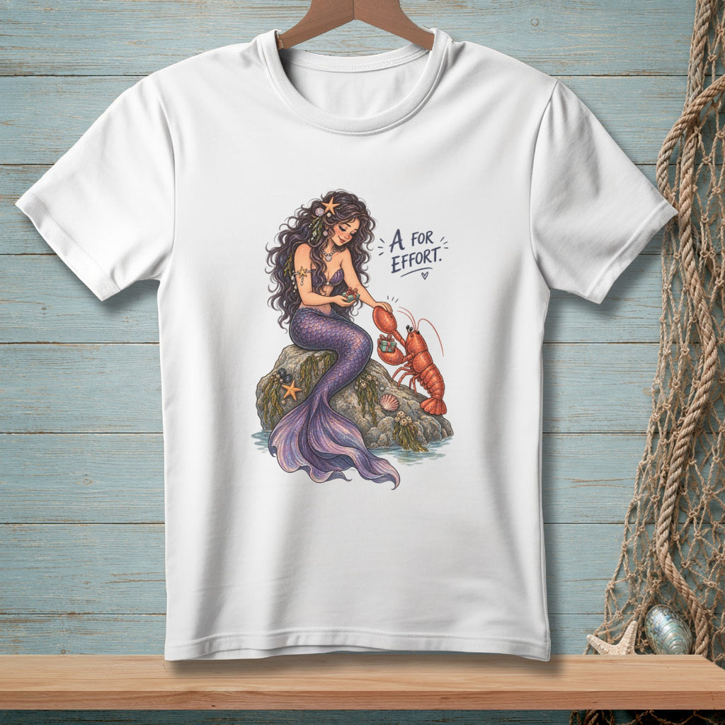 White t-shirt with mermaid giving a lobster a gift, text "A for Effort."
