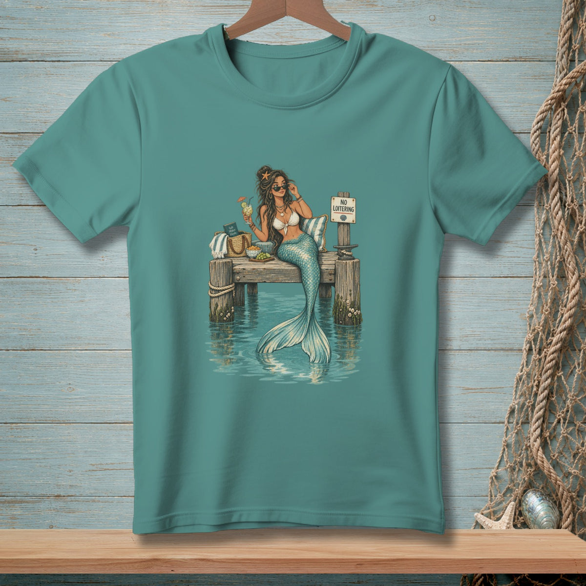 Mermaid relaxing on a pier with a drink and a "No Loitering" sign.