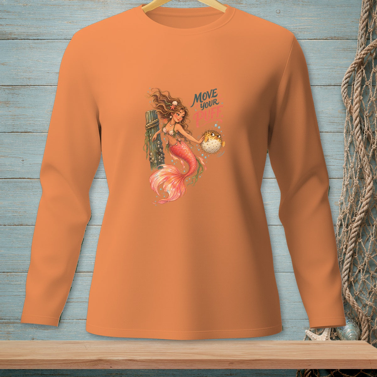 Orange long-sleeve shirt with a mermaid and pufferfish graphic reading "Move Your".