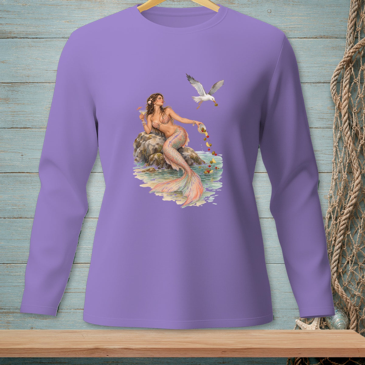 Lavender long sleeve shirt featuring a mermaid and seagull graphic by the water.