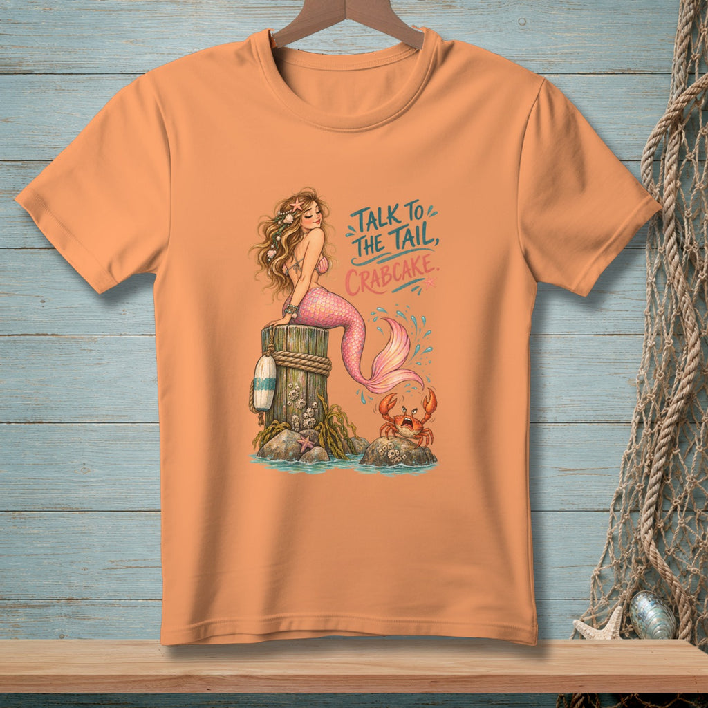 Mermaid and crab illustration on orange t-shirt with text "Talk to the tail, crabcake."
