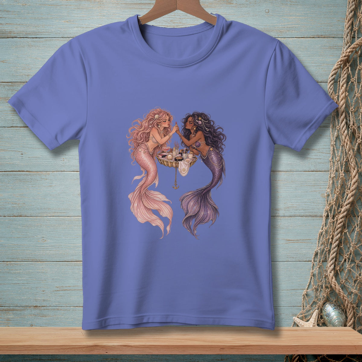 Two mermaids apply makeup at a vanity, one with pink and one with purple tail.