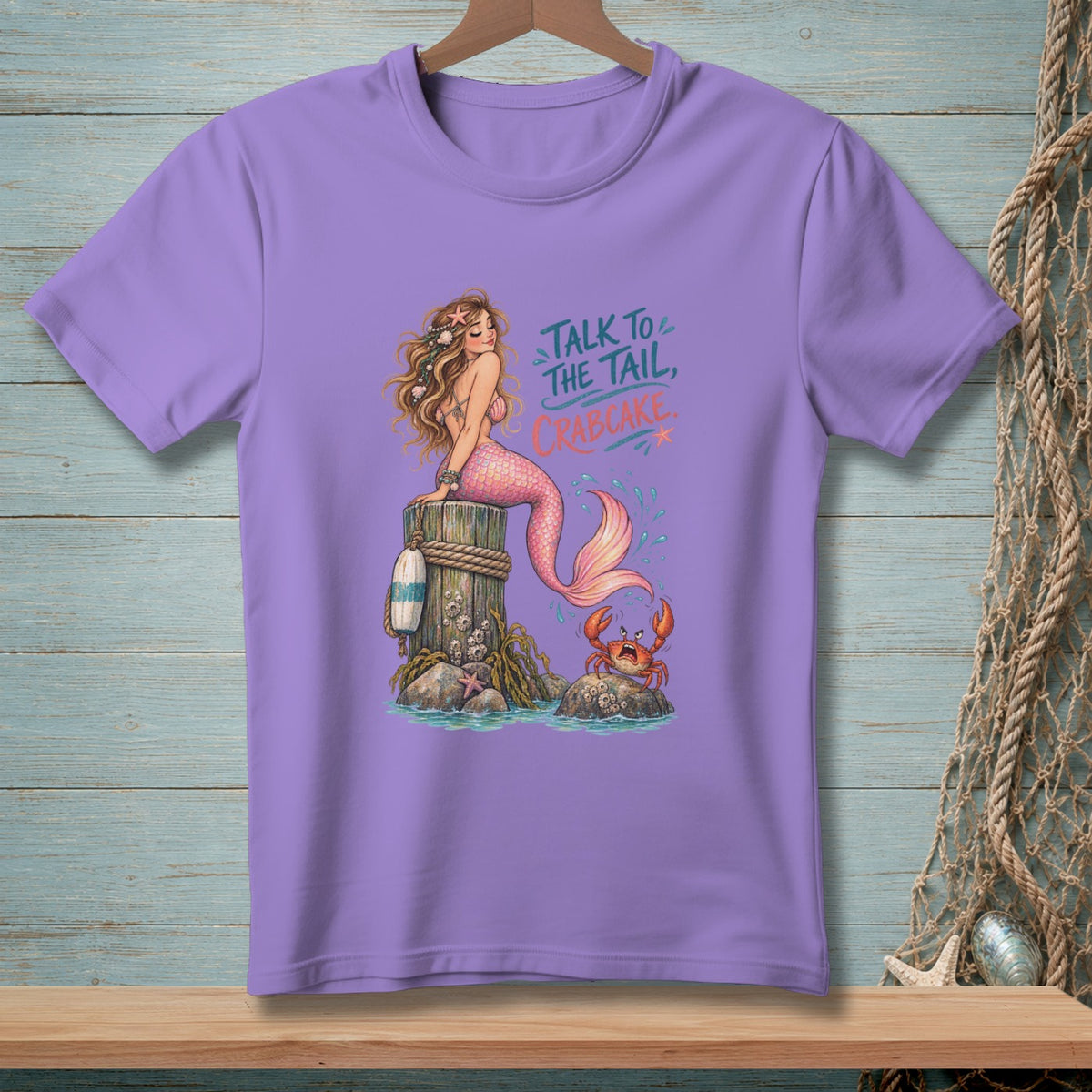 Purple t-shirt with a graphic of a mermaid and an angry crab, saying "Talk to the tail, crabcake."