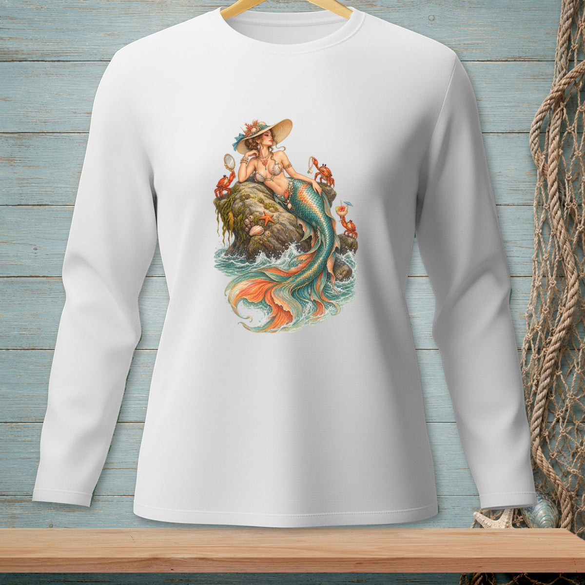 White long-sleeve shirt with a graphic of a mermaid on a rock with crabs and a starfish.