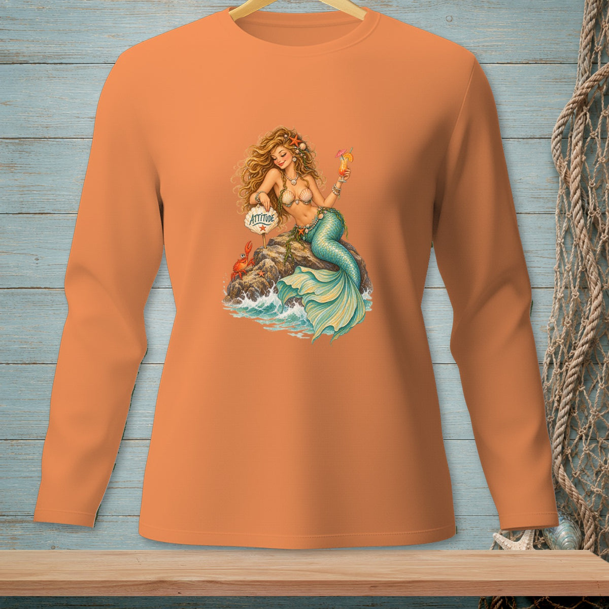 Orange long-sleeve shirt with a mermaid holding a drink and a sign that says "Attitude".