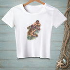 White t-shirt with a graphic of two mermaids by the water.