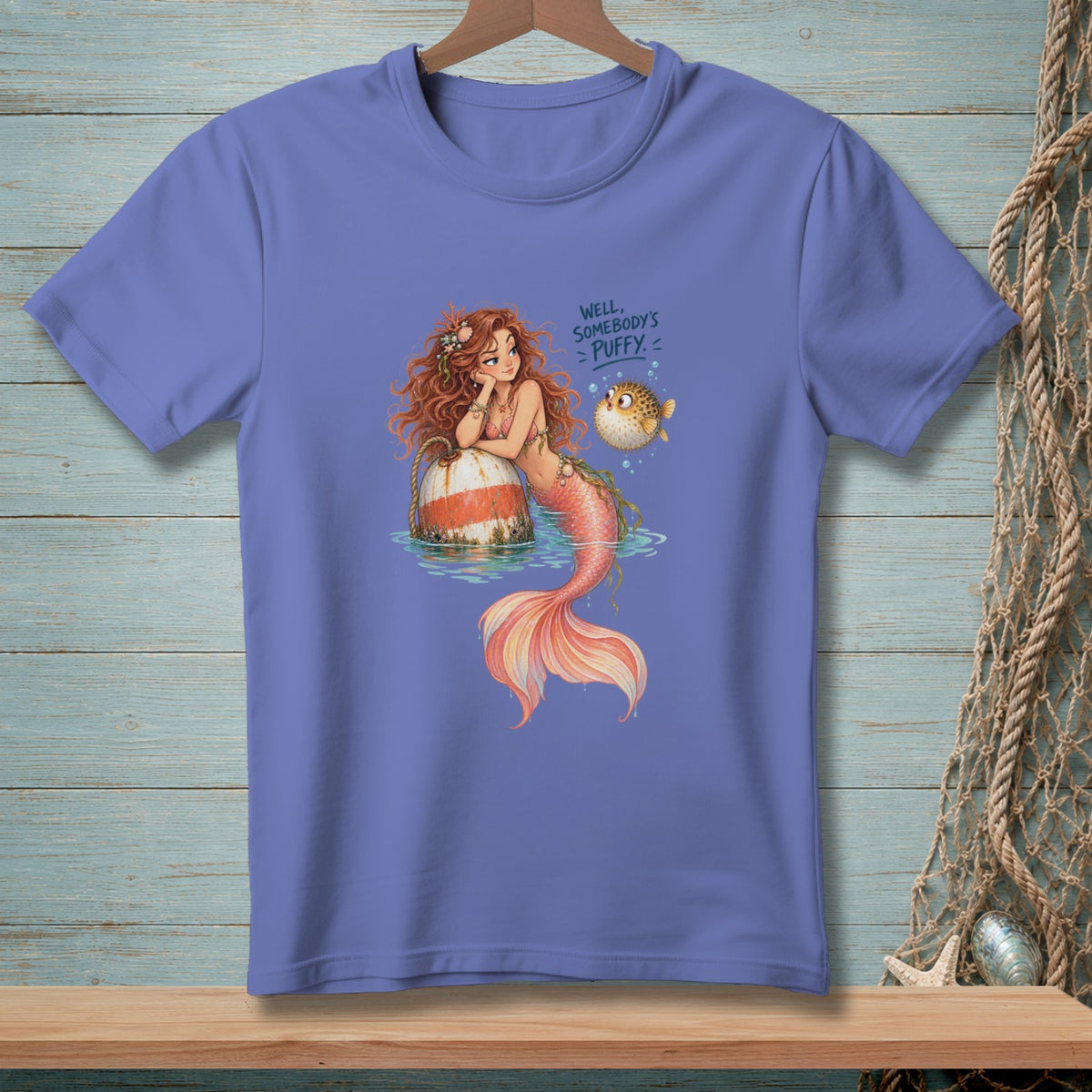Purple t-shirt with a mermaid and pufferfish illustration, reading "Well, somebody's puffy."