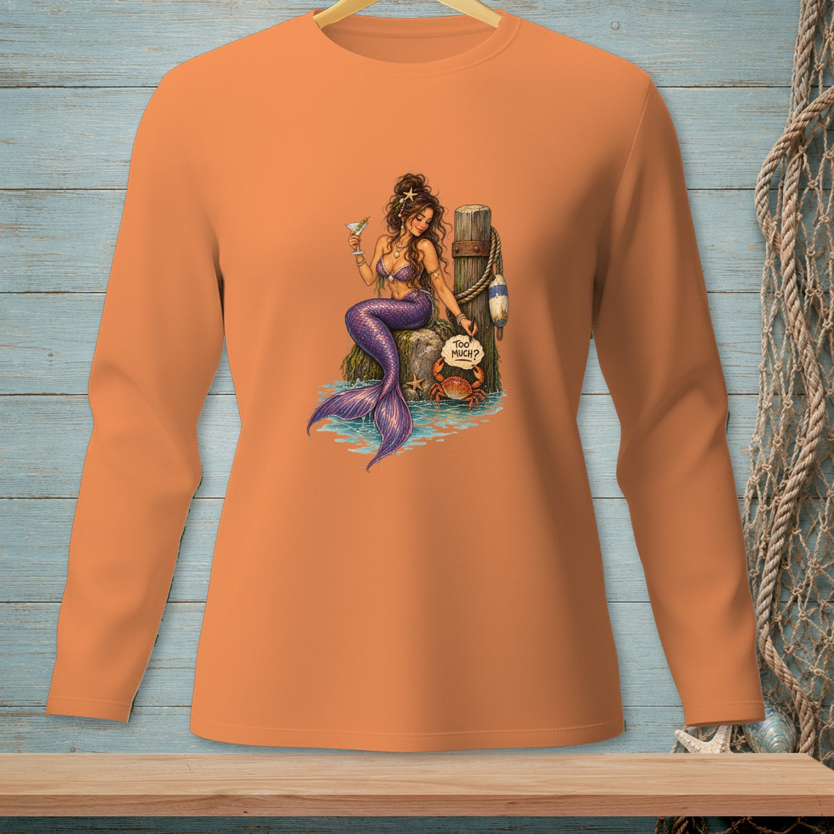 Orange long-sleeve shirt with mermaid, crab, and "Too Much?" text design.