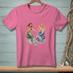 Pink t-shirt with two mermaids sitting on rocks.