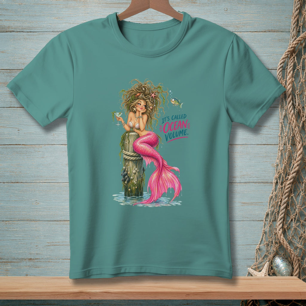 Mermaid with pink tail holding a drink, sitting on a post. Text reads "It's called Ocean Volume."