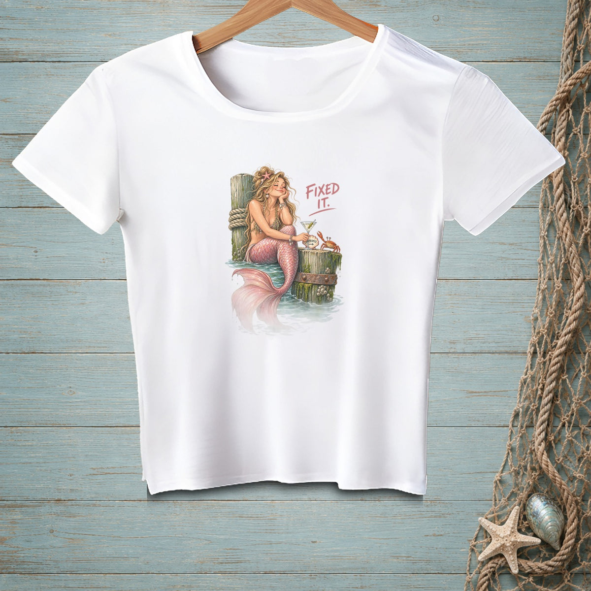 Mermaid sitting on a post with a drink, text says "Fixed It."