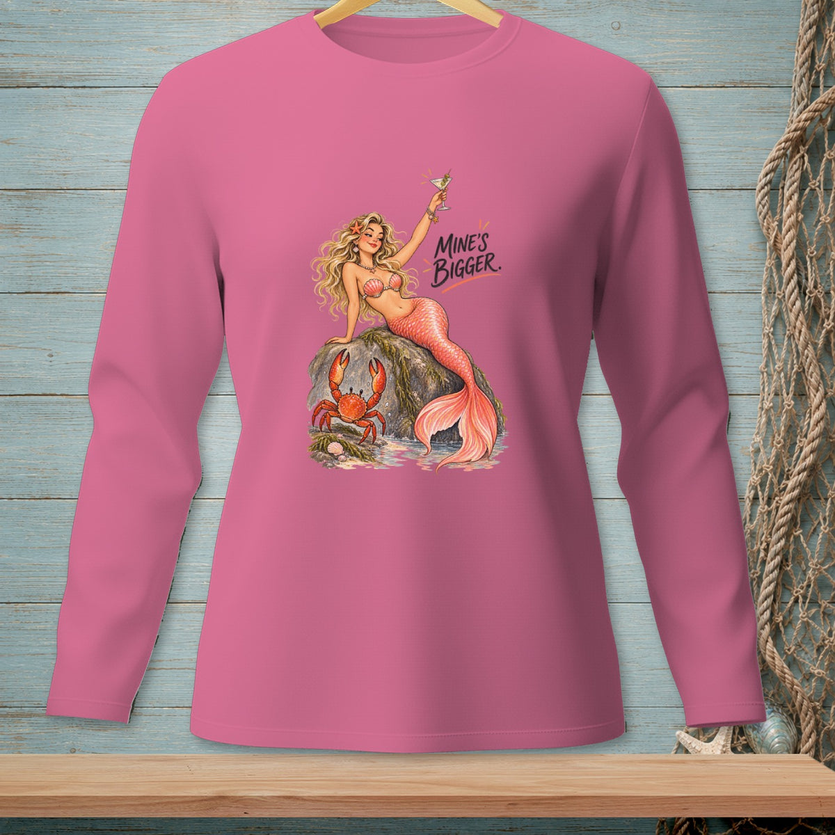 Pink long sleeve shirt with mermaid, crab, and text "MINE'S BIGGER."