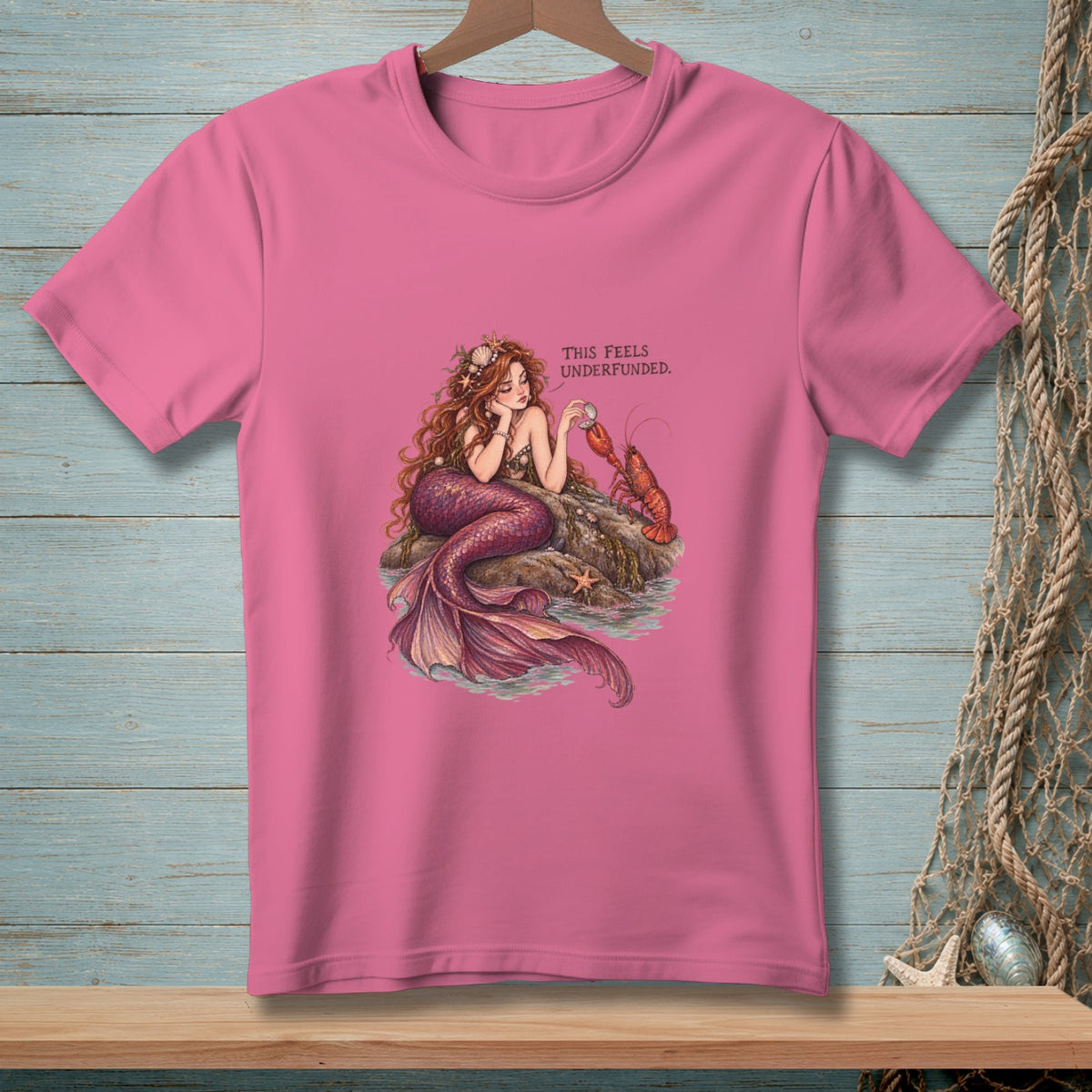 Pink t-shirt with mermaid and lobster illustration and text.