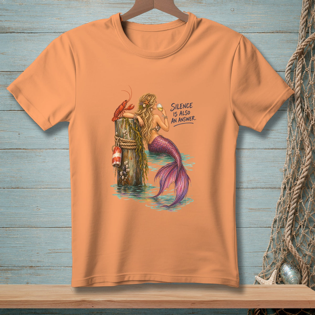 Peach t-shirt with a mermaid, lobster, and text that reads "Silence Is Also An Answer."