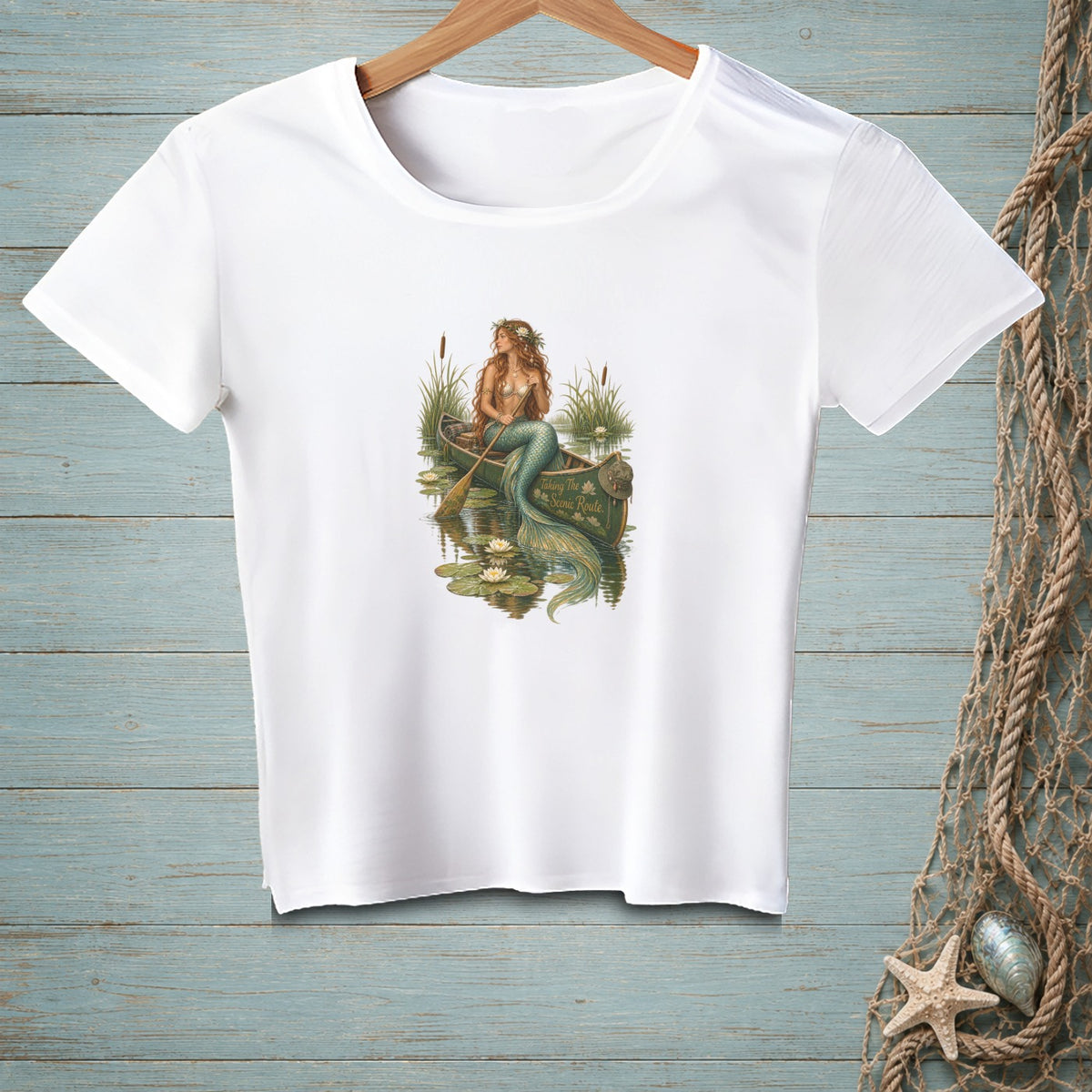 White t-shirt with a mermaid in a canoe, text "Taking The Scenic Route."