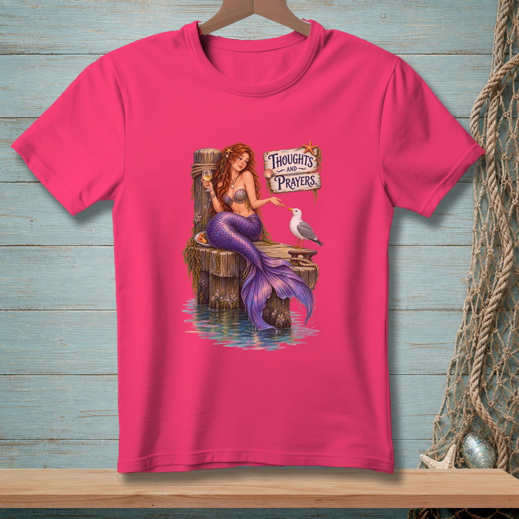 Mermaid sitting on a dock, with a seagull, and a "Thoughts and Prayers" sign.