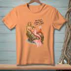 Peach t-shirt with mermaid pouring champagne next to a lobster. Text reads "You keep saying that like it's bad."