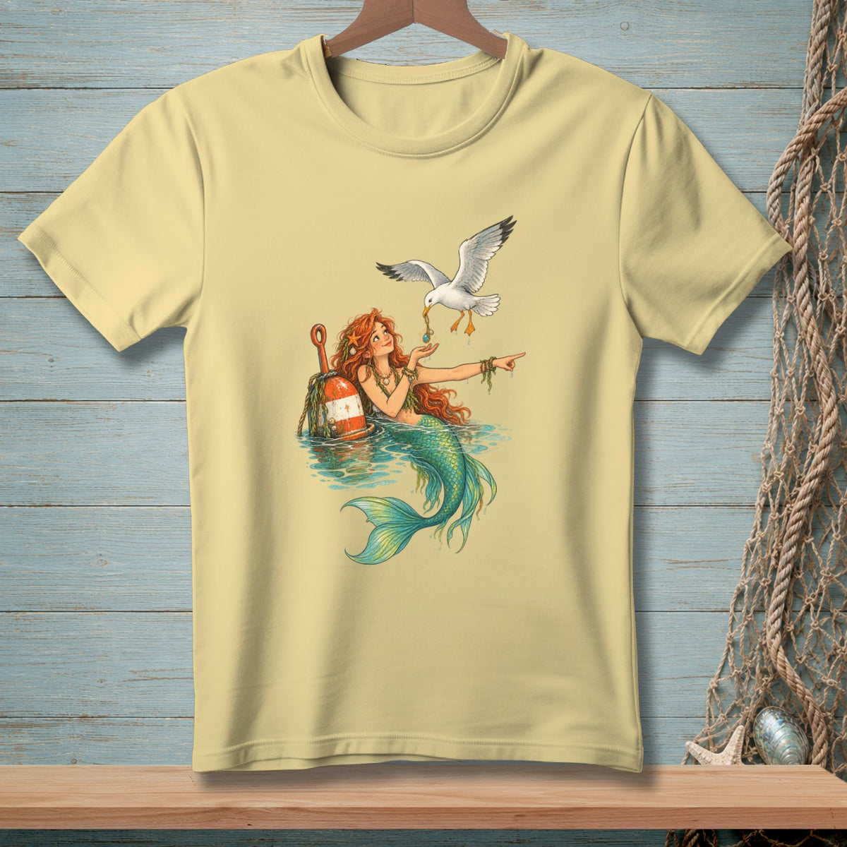 Light yellow t-shirt with a mermaid and seagull graphic.