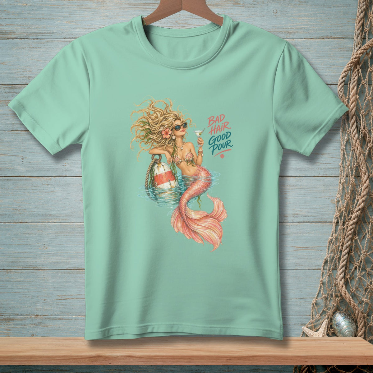Mint green t-shirt with mermaid graphic and text "BAD HAIR GOOD POUR."
