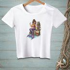White t-shirt with illustration of a mermaid holding a drink, next to a crab and a sign reading "Too Much?".