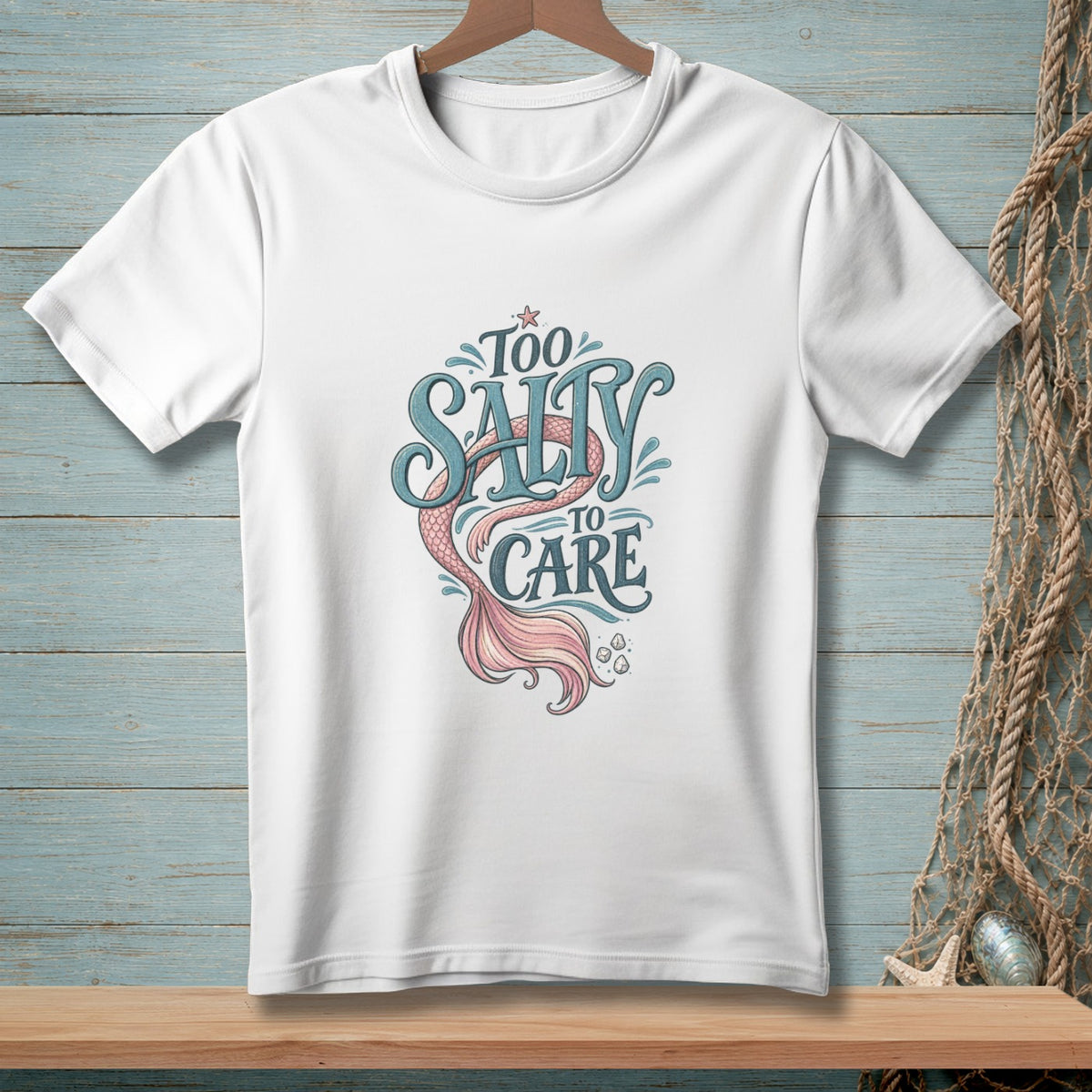 White t-shirt with "Too Salty To Care" mermaid tail graphic.