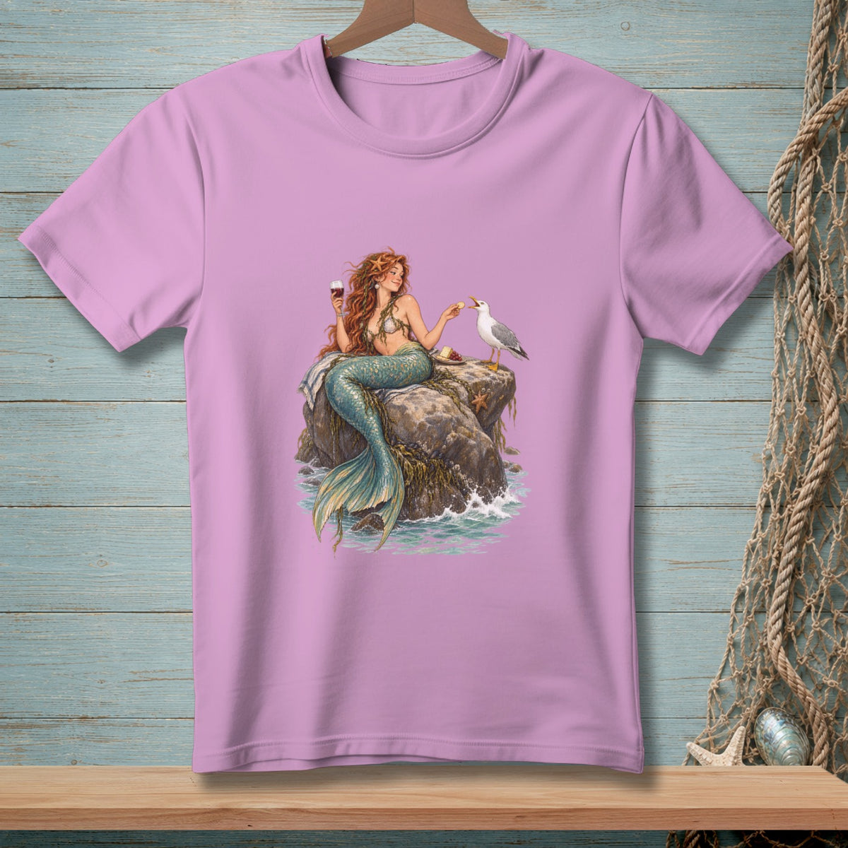 Mermaid with red hair sits on a rock, holding a wine glass, feeding a seagull.