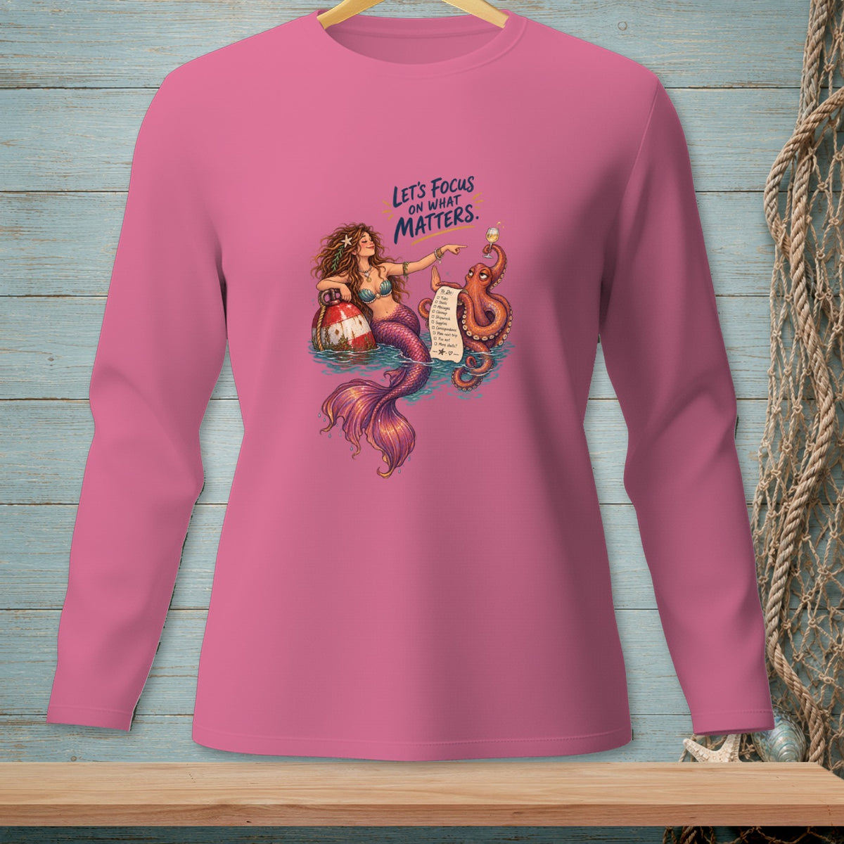 Pink long-sleeve shirt with mermaid, octopus, and to-do list graphic.