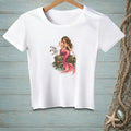 White t-shirt with a printed illustration of a mermaid sitting on rocks with a seagull and a seashell.