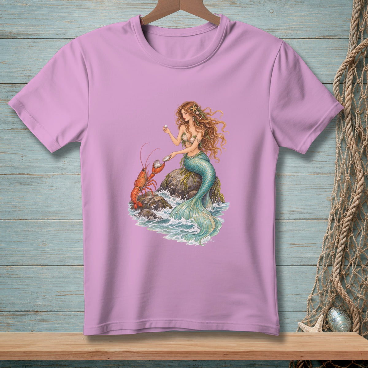 Pink t-shirt with a mermaid and lobster by the ocean waves.