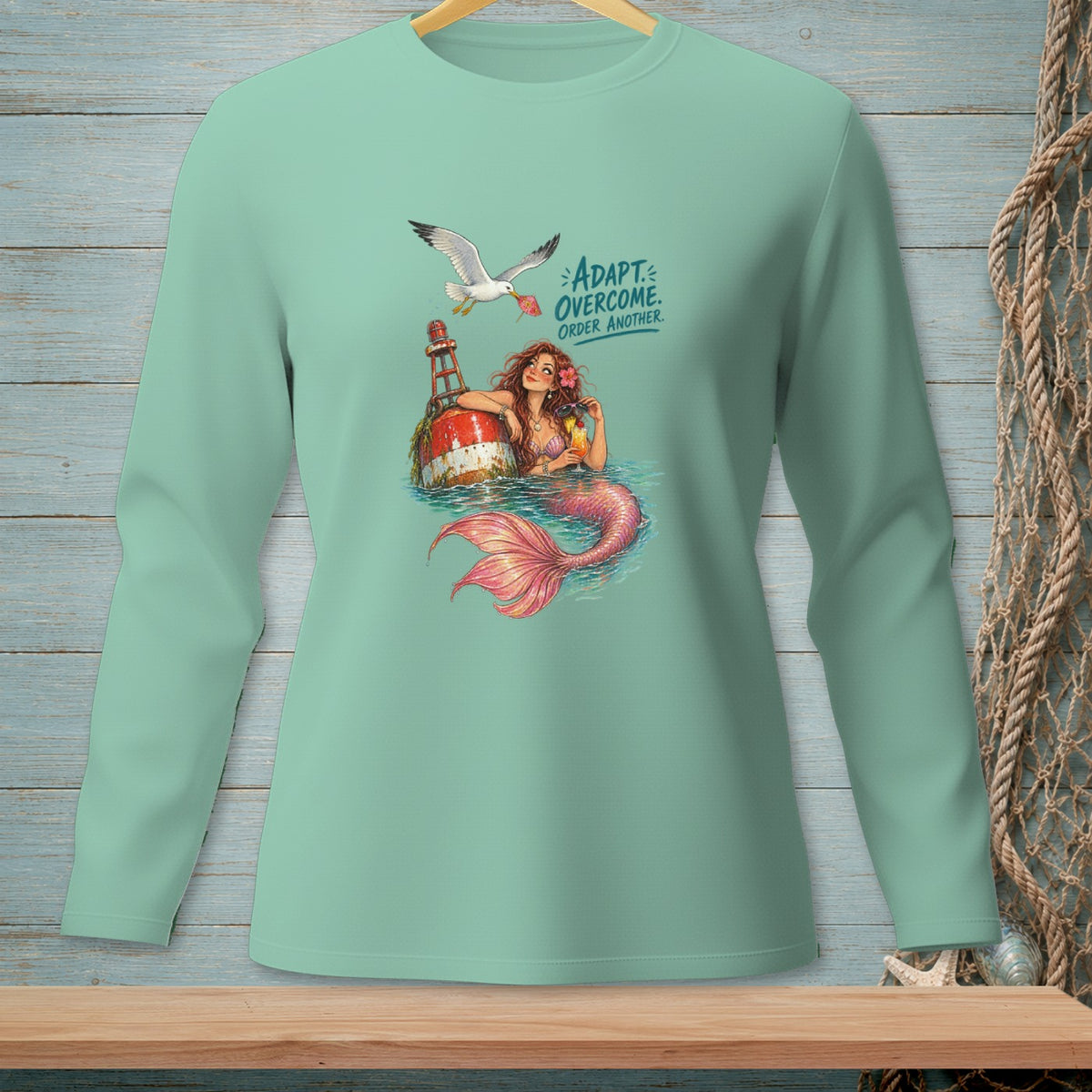 Mermaid with a pink tail sits by a buoy with text "ADAPT OVERCOME. ORDER ANOTHER."