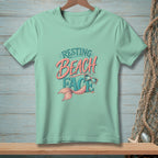 Teal t-shirt with "Resting Beach Face" and mermaid graphic.