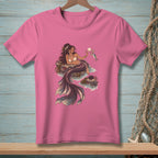 Mermaid holding a shell and a fish, sitting on rocks in the ocean.
