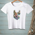 White t-shirt featuring a mermaid with a purple tail, sitting on a dock with a shopping bag.